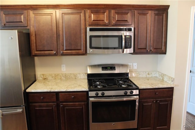 4745 Lynnville, Clay, NY 13041 - kitchen featuring appliances with stainless steel finishes, dark brown cabinets, and light stone counters