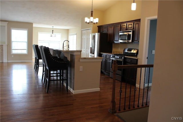 4745 Lynnville, Clay, NY 13041 - kitchen with stainless steel appliances, a chandelier, a kitchen breakfast bar, an island with sink, and dark wood finished floors