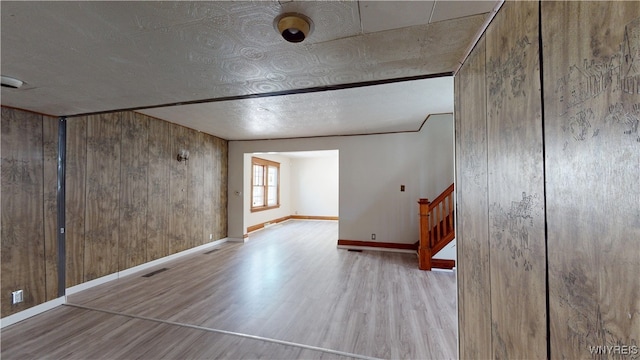 133 Freund St, Buffalo, NY 14215 - empty room with wood finished floors, wooden walls, and stairs
