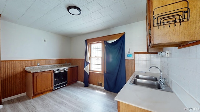 133 Freund St, Buffalo, NY 14215 - kitchen featuring dishwasher, a wainscoted wall, brown cabinetry, light wood-style floors, and light countertops