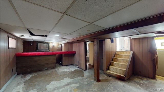 133 Freund St, Buffalo, NY 14215 - indoor dry bar featuring unfinished concrete flooring, a paneled ceiling, stairway, and wood walls