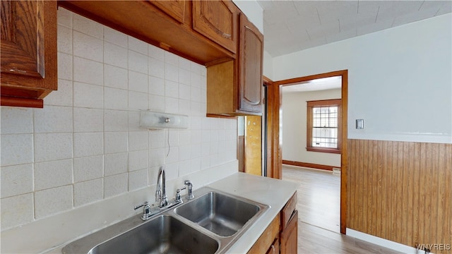 133 Freund St, Buffalo, NY 14215 - kitchen with light countertops, light wood-style floors, brown cabinetry, and tasteful backsplash