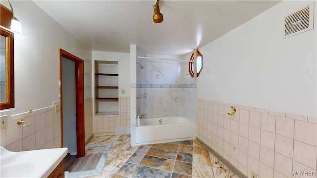 133 Freund St, Buffalo, NY 14215 - bathroom with tile walls, vanity, bathtub / shower combination, and a wainscoted wall