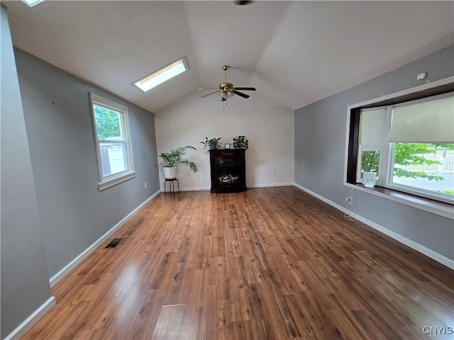 259 Flower Ave W, Watertown-City, NY 13601 - unfurnished living room featuring ceiling fan, vaulted ceiling, a skylight, wood finished floors, and a fireplace