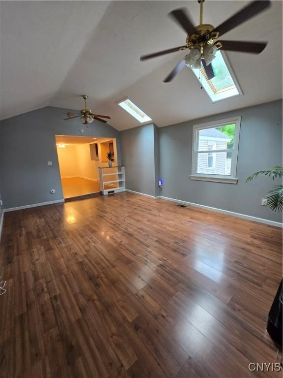 259 Flower Ave W, Watertown-City, NY 13601 - unfurnished living room featuring a skylight, a ceiling fan, vaulted ceiling, and wood finished floors