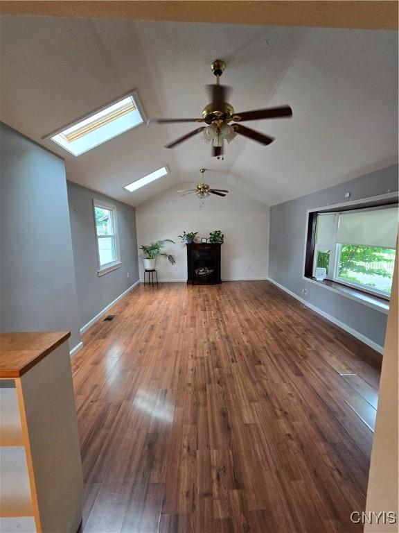 259 Flower Ave W, Watertown-City, NY 13601 - unfurnished living room with ceiling fan, vaulted ceiling, a skylight, hardwood / wood-style flooring, and a fireplace