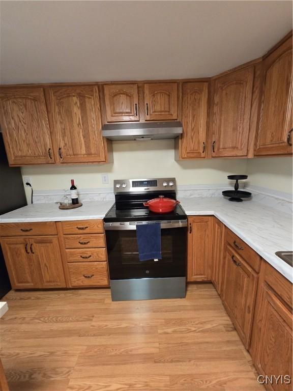259 Flower Ave W, Watertown-City, NY 13601 - kitchen featuring stainless steel range with electric stovetop, under cabinet range hood, light countertops, and light wood-style floors