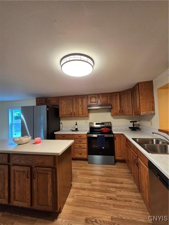 259 Flower Ave W, Watertown-City, NY 13601 - kitchen featuring appliances with stainless steel finishes, under cabinet range hood, light wood finished floors, and brown cabinets