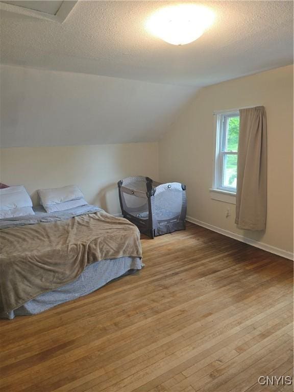 259 Flower Ave W, Watertown-City, NY 13601 - bedroom with wood-type flooring, lofted ceiling, and a textured ceiling