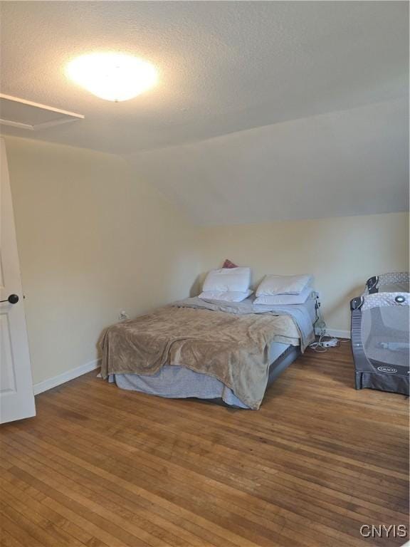 259 Flower Ave W, Watertown-City, NY 13601 - bedroom with lofted ceiling, wood finished floors, and a textured ceiling