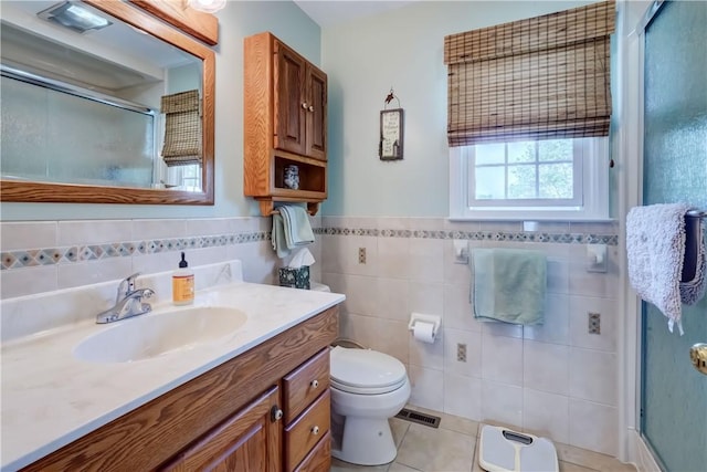 921 Wayneport Rd, Macedon, NY 14502 - full bath featuring a stall shower, vanity, tile walls, tile patterned flooring, and wainscoting