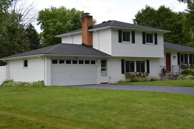57 Timberline Dr, Penfield, NY 14526 - view of front of home featuring a chimney, an attached garage, a front yard, and asphalt driveway