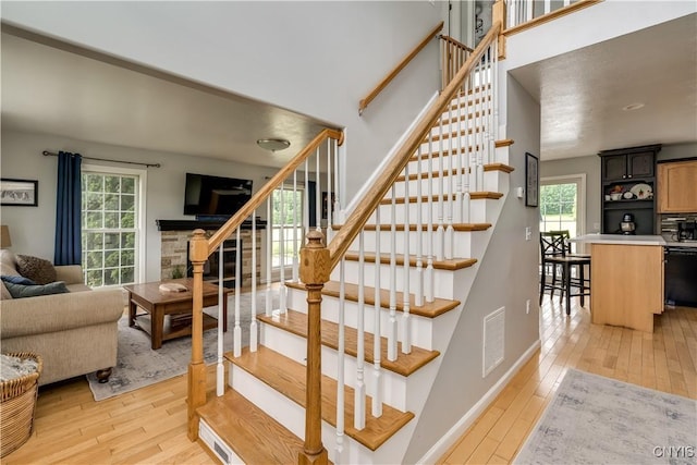 33039 County Route 22, Antwerp, NY 13691 - staircase with wood-type flooring and a stone fireplace