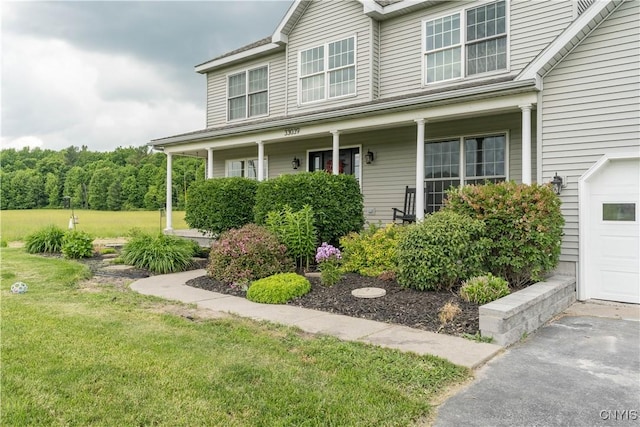 33039 County Route 22, Antwerp, NY 13691 - view of front of home with a porch, a garage, and a front lawn