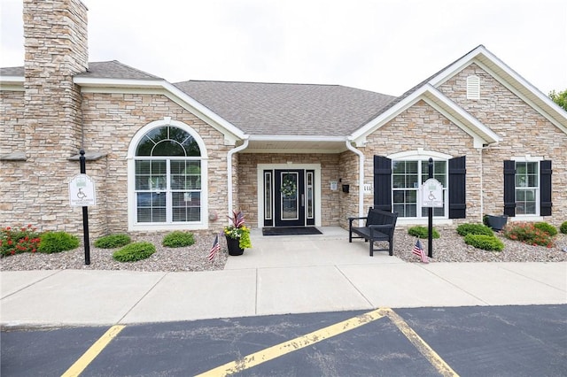 148 Maryview Dr Unit 148, Webster, NY 14580 - doorway to property with stone siding, roof with shingles, and a chimney