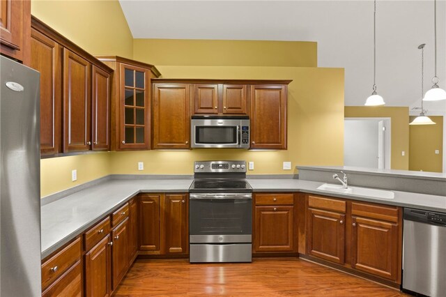189 Maryview Dr, Penfield, NY 14580 - kitchen with appliances with stainless steel finishes, glass insert cabinets, decorative light fixtures, wood finished floors, and light countertops