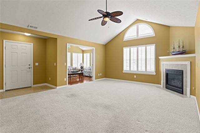 189 Maryview Dr, Penfield, NY 14580 - unfurnished living room featuring a ceiling fan, vaulted ceiling, a tiled fireplace, and carpet
