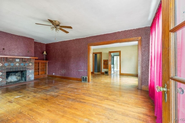 218-20 Avery Ave, Syracuse, NY 13204 - unfurnished living room with a ceiling fan, wood finished floors, and a brick fireplace