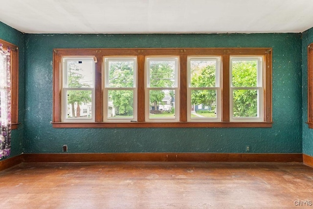 218-20 Avery Ave, Syracuse, NY 13204 - empty room with healthy amount of natural light, wood finished floors, and a textured wall