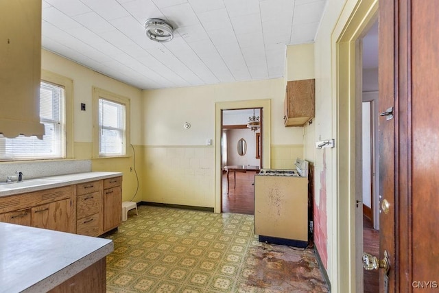 218-20 Avery Ave, Syracuse, NY 13204 - kitchen with range, tile patterned floors, a wainscoted wall, and light countertops