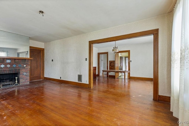 218-20 Avery Ave, Syracuse, NY 13204 - unfurnished living room with wood finished floors, a fireplace with flush hearth, and a textured wall