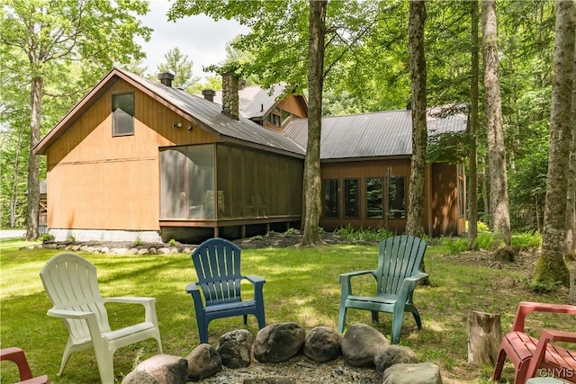 8782 Buck Point Rd, Watson, NY 13367 - back of property with a chimney, a sunroom, a yard, and a metal roof