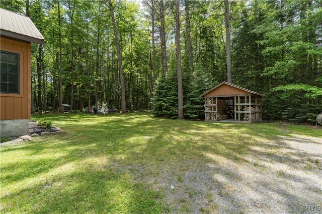 8782 Buck Point Rd, Watson, NY 13367 - view of grassy yard with an outdoor structure and a forest view