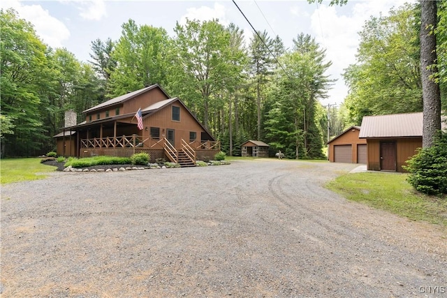 8782 Buck Point Rd, Watson, NY 13367 - view of front facade with an outbuilding, a detached garage, a porch, and a chimney