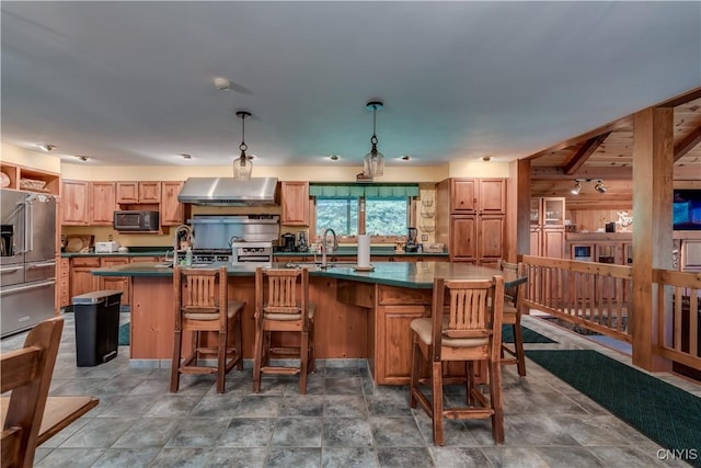 8782 Buck Point Rd, Watson, NY 13367 - kitchen with wall chimney exhaust hood, high quality fridge, dark countertops, an island with sink, and pendant lighting