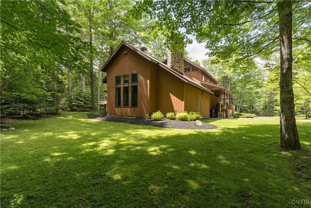 8782 Buck Point Rd, Watson, NY 13367 - view of home's exterior featuring a chimney and a lawn