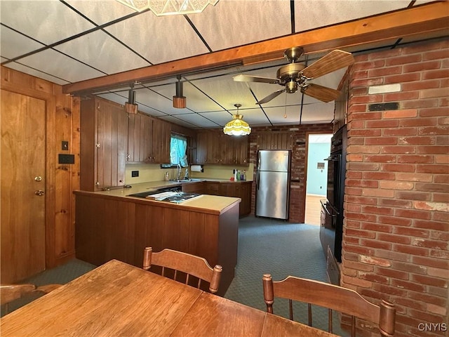 5877 State Route 233, Westmoreland, NY 13440 - kitchen featuring freestanding refrigerator, dark carpet, ceiling fan, a peninsula, and wooden walls