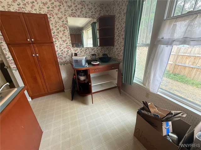 75 Main St, North Dansville, NY 14437 - kitchen with wallpapered walls, open shelves, brown cabinetry, and light floors