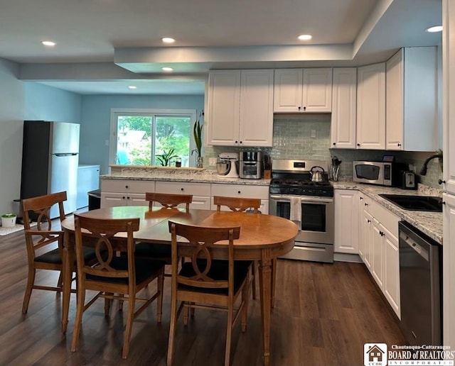 12 Juliet St, Jamestown, NY 14701 - kitchen featuring stainless steel appliances, dark wood-type flooring, white cabinets, decorative backsplash, and recessed lighting