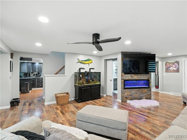 5137 William St, Lancaster, NY 14086 - living room featuring ceiling fan, wood finished floors, recessed lighting, and a stone fireplace