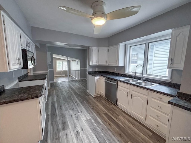 221 82nd St, Niagara Falls, NY 14304 - kitchen featuring appliances with stainless steel finishes, dark countertops, white cabinetry, light wood-style floors, and a ceiling fan