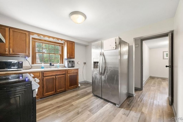 9 Lawrence Ave, New Hartford, NY 13413 - kitchen featuring stainless steel appliances, light countertops, brown cabinets, and light wood-type flooring