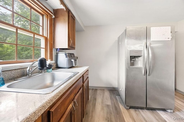 9 Lawrence Ave, New Hartford, NY 13413 - kitchen featuring stainless steel fridge with ice dispenser, light wood-style floors, brown cabinets, and light countertops