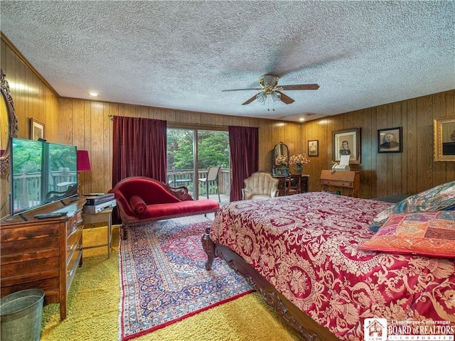 5152 John Darling Rd, Conowingo, NY 14726 - bedroom with carpet floors, a textured ceiling, wooden walls, access to outside, and a ceiling fan