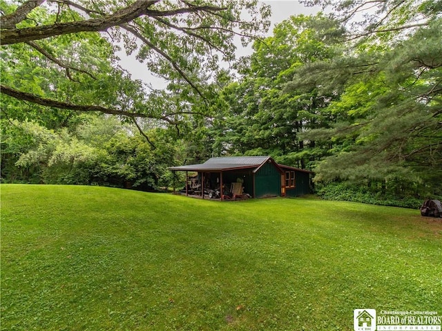 5152 John Darling Rd, Conowingo, NY 14726 - view of grassy yard with an outbuilding, an outdoor structure, and a forest view