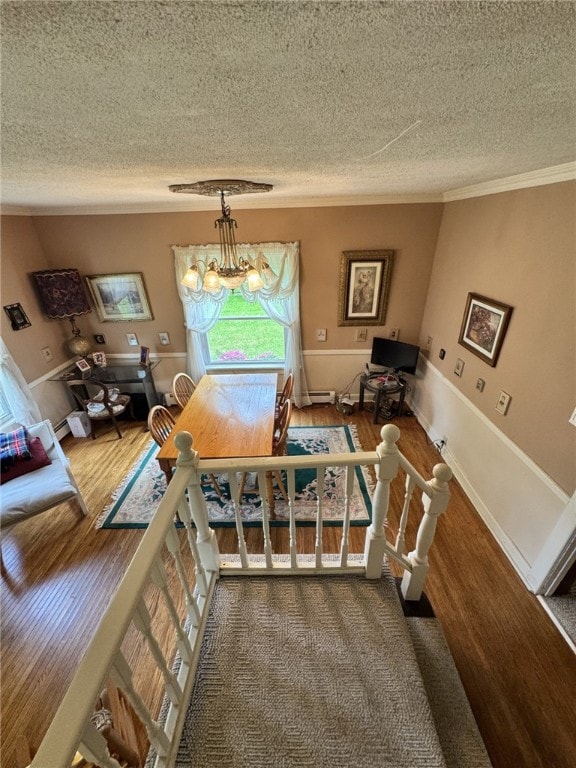 66 W Benton Ave, Port Allegany Boro, PA 16743 - dining area featuring a textured ceiling, ornamental molding, a chandelier, wood finished floors, and a baseboard heating unit