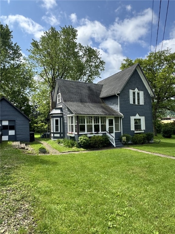 66 W Benton Ave, Port Allegany Boro, PA 16743 - view of front facade with a detached garage, a front lawn, roof with shingles, and an outbuilding