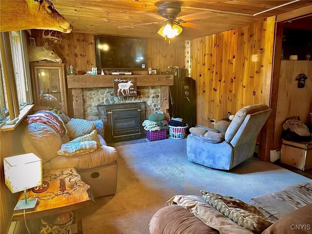 5767 W Main St, West Turin, NY 13325 - carpeted living room with wood ceiling, wood walls, a ceiling fan, and a stone fireplace