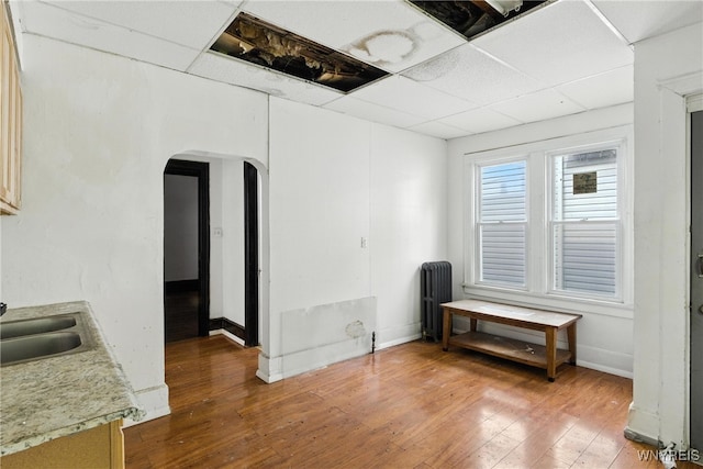 49 Urban St, Buffalo, NY 14211 - spare room featuring arched walkways, radiator heating unit, hardwood / wood-style floors, and a drop ceiling