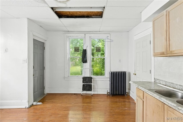 49 Urban St, Buffalo, NY 14211 - kitchen featuring radiator heating unit, light brown cabinets, light wood finished floors, a paneled ceiling, and light countertops