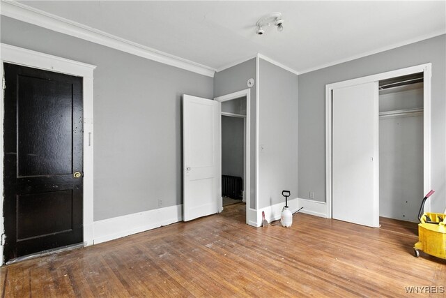 49 Urban St, Buffalo, NY 14211 - unfurnished bedroom with crown molding, wood finished floors, radiator heating unit, and a closet