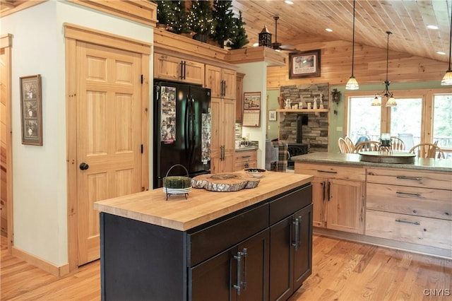 105 Garmon Ave, Webb, NY 13420 - kitchen with freestanding refrigerator, wooden counters, a wood stove, lofted ceiling, and light wood finished floors