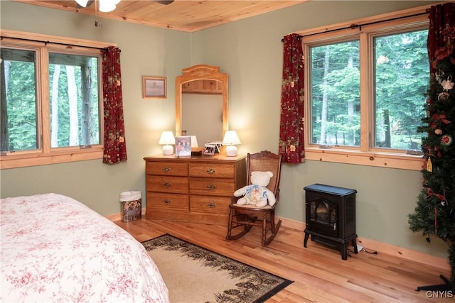 105 Garmon Ave, Webb, NY 13420 - bedroom with wood ceiling, wood finished floors, and a wood stove