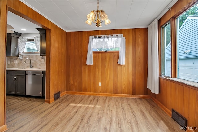 144 Flohr Ave, West Seneca, NY 14224 - unfurnished dining area featuring plenty of natural light, a chandelier, light wood finished floors, and wood walls
