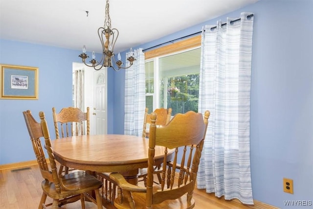 3212 Hickox Rd, Hamburg, NY 14075 - dining area with a chandelier and light wood-style floors