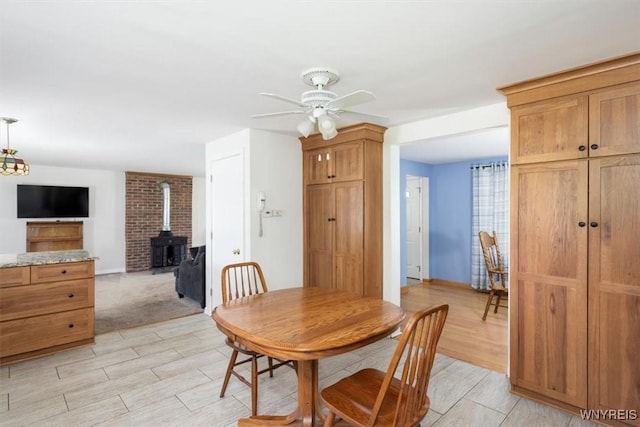 3212 Hickox Rd, Hamburg, NY 14075 - dining space with a wood stove, ceiling fan, and light wood-type flooring